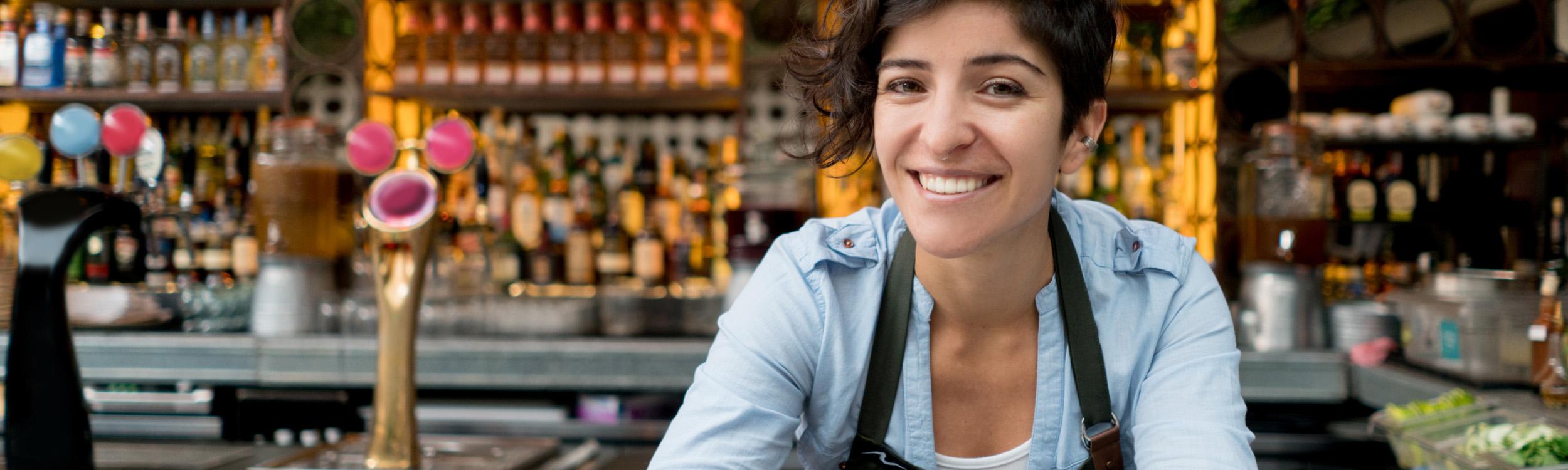 female buisiness owner smiling in front of her bar