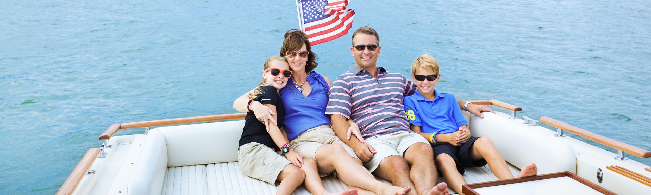 family of 4 siting together on a boat